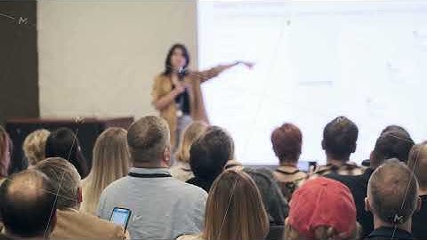 Speaker presents at conference with audience recording slides mi