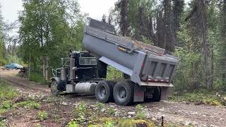 Efficient Gravel Delivery: 12 cu. yards Unloaded Evenly by Dump Truck for Campground Road.