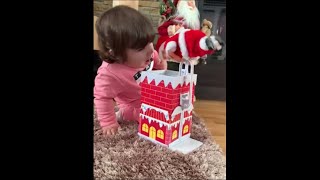 Little Girl Fascinated With Her New Moving Santa Toy