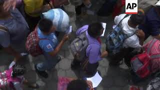 Migrants break through fence at border, wait to cross bridge into Mexico