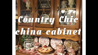In this video I decorate my china cabinet with a variety of different pieces in similar colors for an eclectic country chic style. I take you 