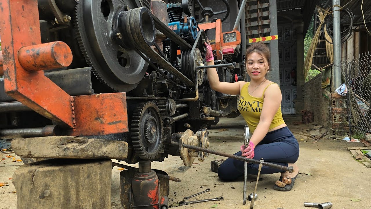 The female mechanic replaced the axle bearings on a massive tractor.