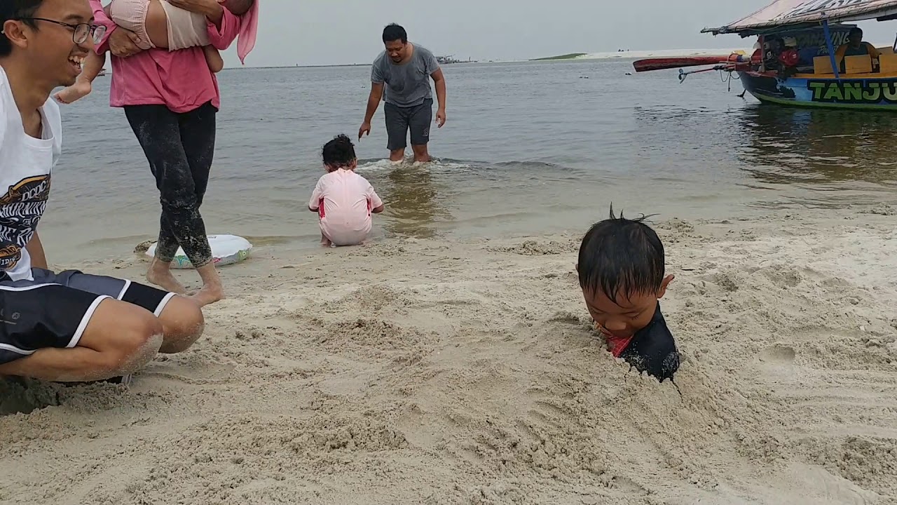 Holiday Traveling to Ancol Beach Jakarta - Buried in the sand