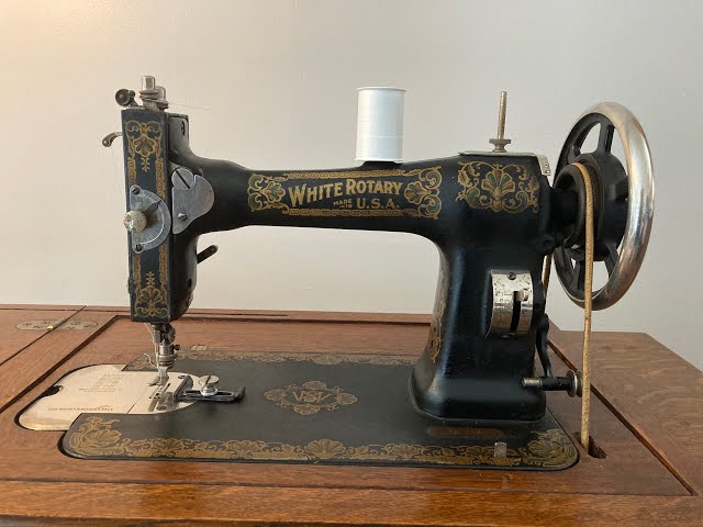 Vintage Singer sewing machine threaded with spool of white thread