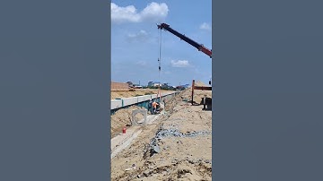 Workers install drainage system with Mobile crane