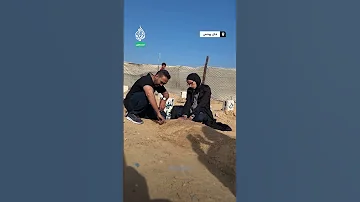 الصحفية هلا تجلس بجوار قبر خطيبها مصور قناة الجزيرة محمد سلامة 