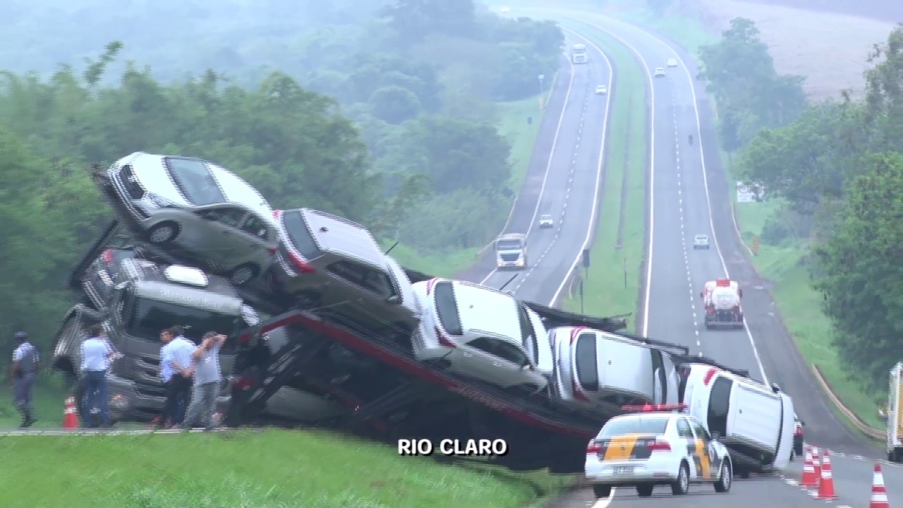 Carro fica destruído após cair de caminhão-cegonha que entalou em