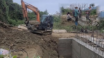 Cầu Khe Trang.Máy xúc san lấp đất kè đá đầu mố trụ khủng. Dân bản thạo việc buộc sắt cột trụ lên cao