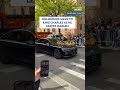Onlookers wave to King Charles as he leaves Harlem