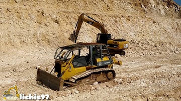 The Komatsu D85ESS bulldozer works to push the results of the ripper