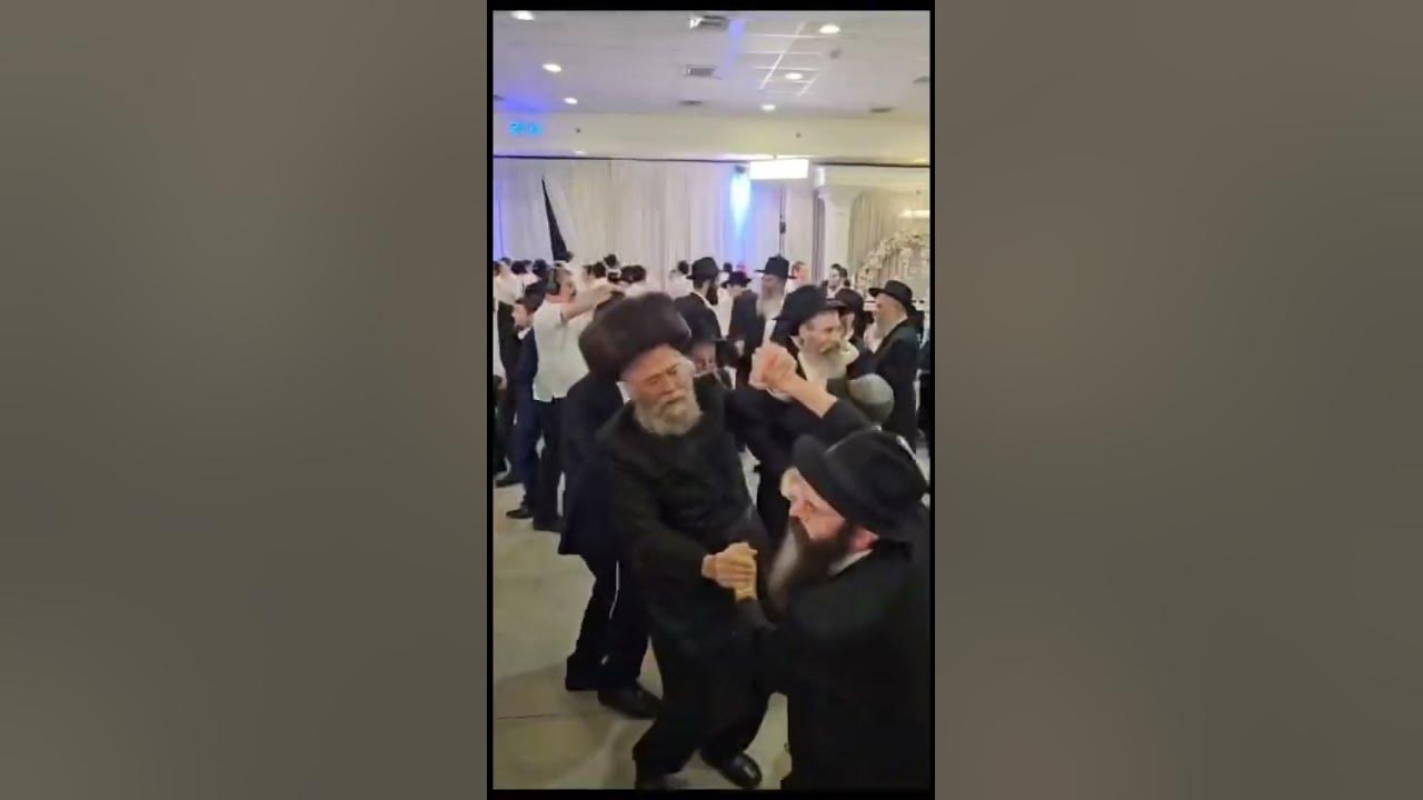 Two Hasidic men dancing by a Jewish wedding