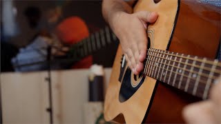 Guitarist tapping and swinging over strings of the guitar