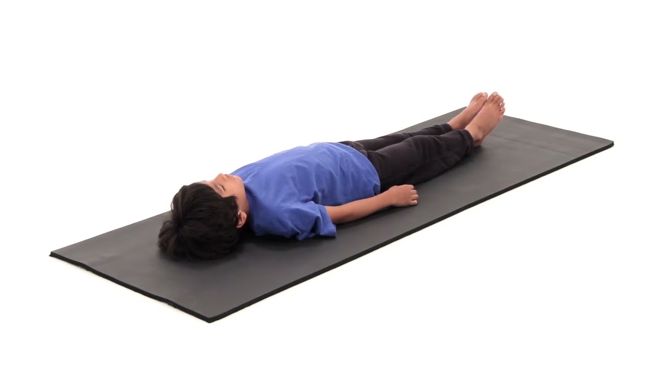 A child lies on a black exercise mat for Medbridge healthcare education and hybrid care.