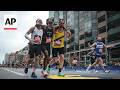 Boston Marathon runners help another runner who collapsed finish the race