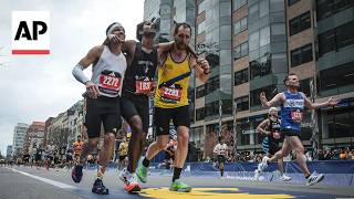 Boston Marathon runners help another runner who collapsed finish the race