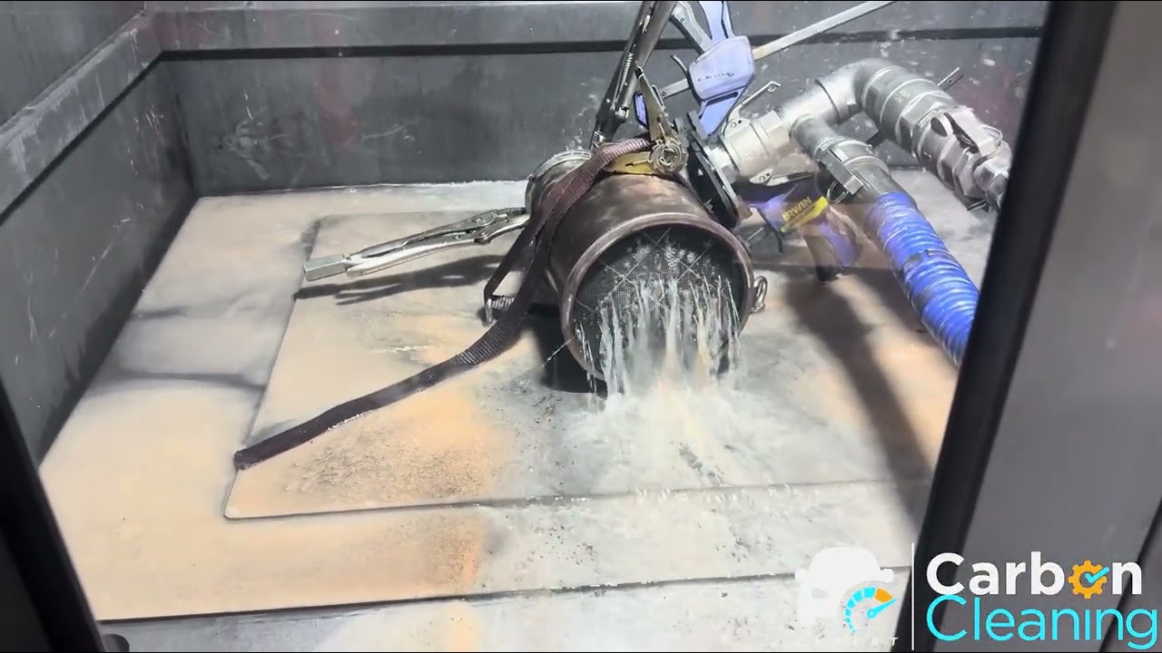 A diesel particulate filter off the car in the wash cabinet at the Kings Park workshop, soot flushing out under water pressure