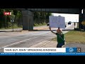 ‘Sign Guy John’ spreads smiles one honk at a time