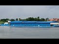 A barge under the Lithuanian flag carries cargo along the Neman River. River shipping, inland waters