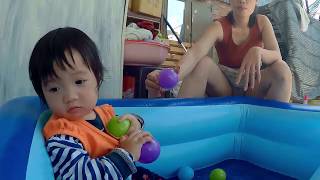 Beautiful single mom with baby playing toys in small pool