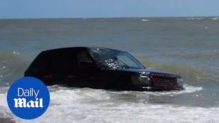 Range Rover swamped by tide and faces being washed into sea