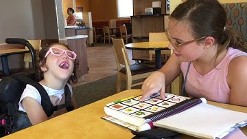 Sisters talking with PODD and partner assisted scanning