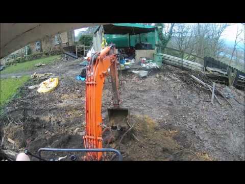 Digging a banking and piling soil behind ready for loading with an IHI Mini Digger
