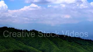 Timelapse of clouds casting shadows on rolling green hills. (high speed)