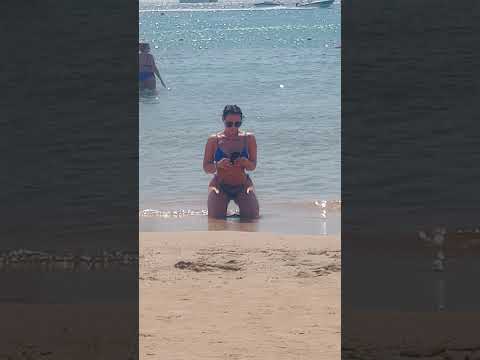 Top model in spiaggia alla ricerca della luce perfetta 