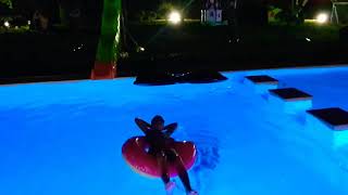 Sami play in the pool at night