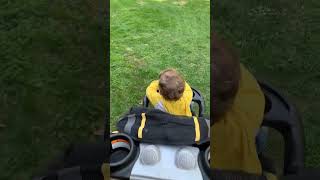 Boy wearing ghillie suit head runs towards playground in backyard then jumps on yellow trapeze bar