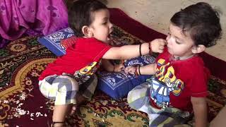 Twins baby feeding each other