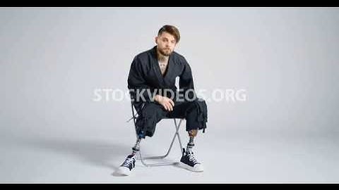 bilateral amputee man sitting on chair,...