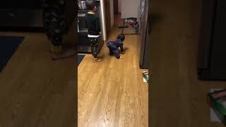 Boy plays with RC toy car in kitchen then trips and bumps his head on over