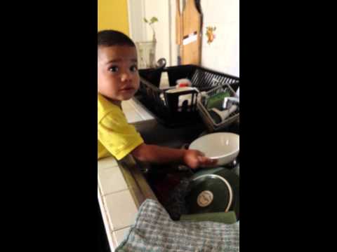 Little boy washing dishes