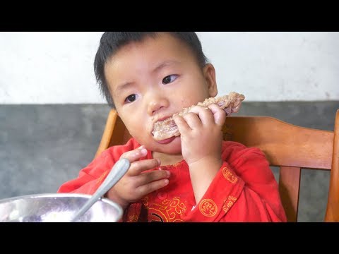 The wife boil duck soup, the baby two hands take duck wing, chew very sweet