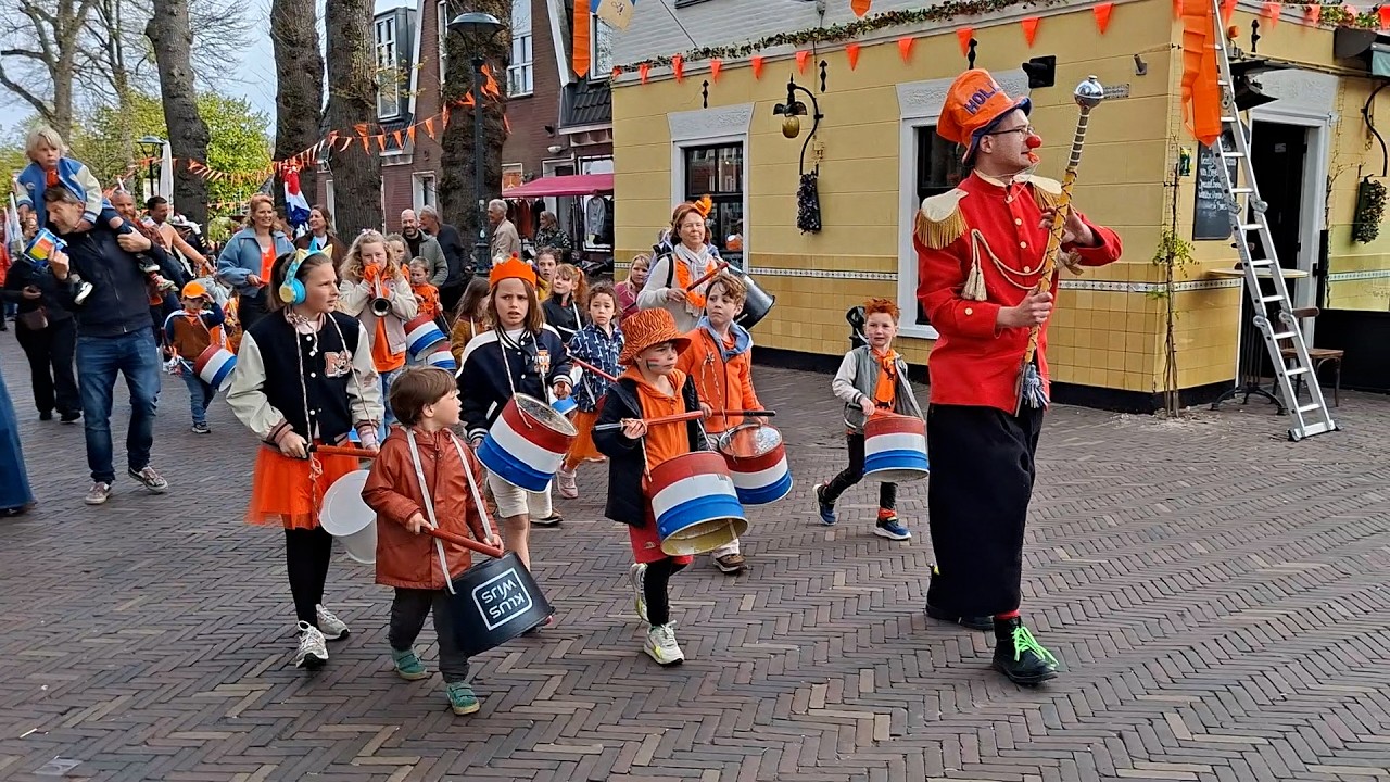 Oranjegekte in Bergen NH met oldtimers, lawaaischoppers en feestende inwoners