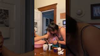 Mom pull out her daughter's tooth with string and she spits it out into bowl