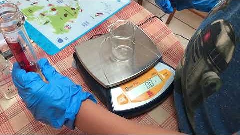 Measuring the mass of an unknown liquid using an electronic pan balance.