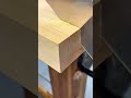 cutting wood into two rectangular blocks making three small square indentations at the corners