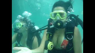 Two Female Scuba Divers On Sandy Floor