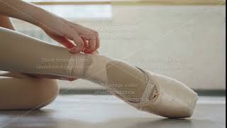 Close-Up Shot Of Little Girls Foot In Pointe Shoe And Hands Putting On Professional Footwear And