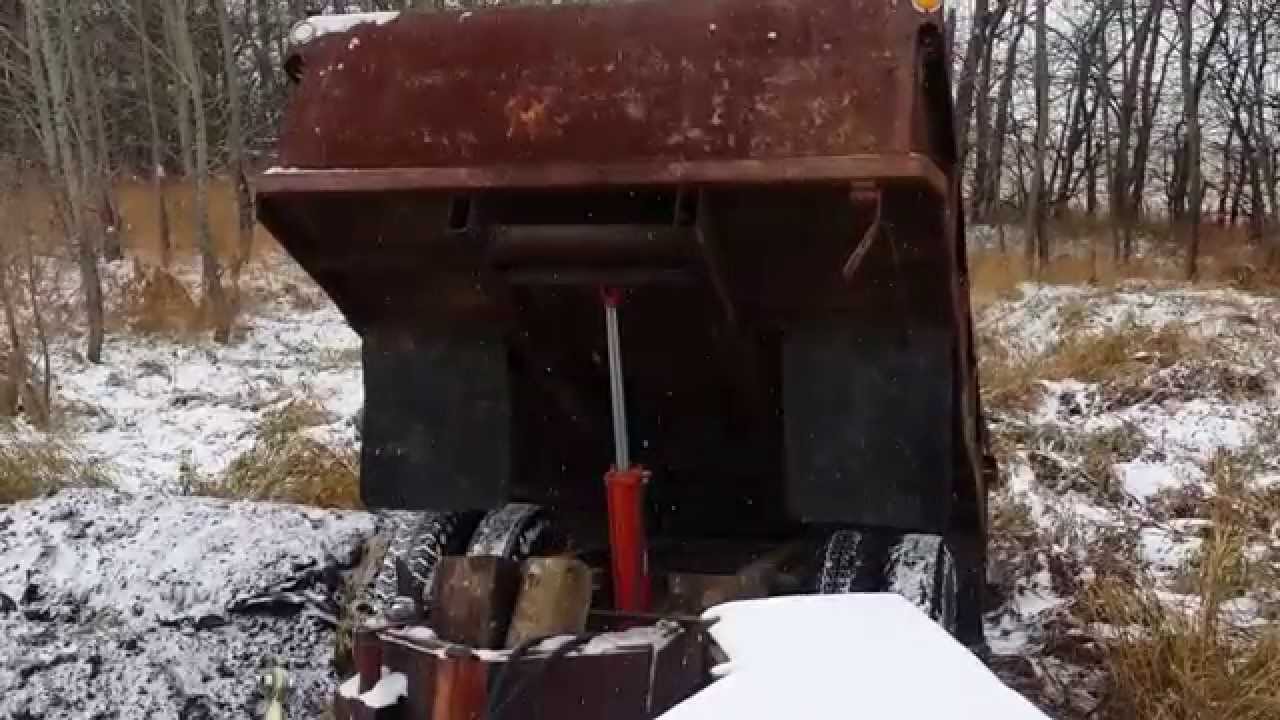 Unimog U1700AG with dump trailer dumping dirt.