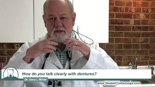 How do you talk clearly with dentures?
