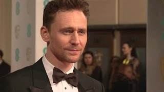 Tom Hiddleston poses on the red carpet of the EE BAFTAs 2015