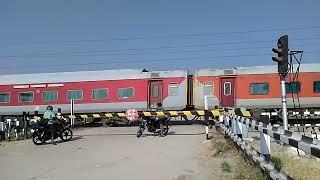 The Red Train thrashes a Level crossing-Indian Railways YPR GKP Exp