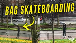 Guy Holds a Bag and Utilizes the Strong Wind to Skateboard Effortlessly