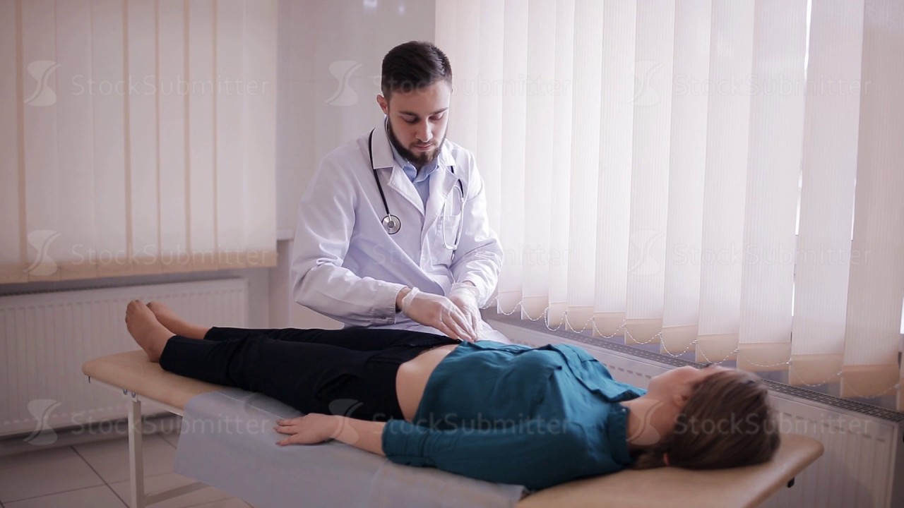 Male Doctor Makes Palpation Of The Abdomen Of The Patient The Girl