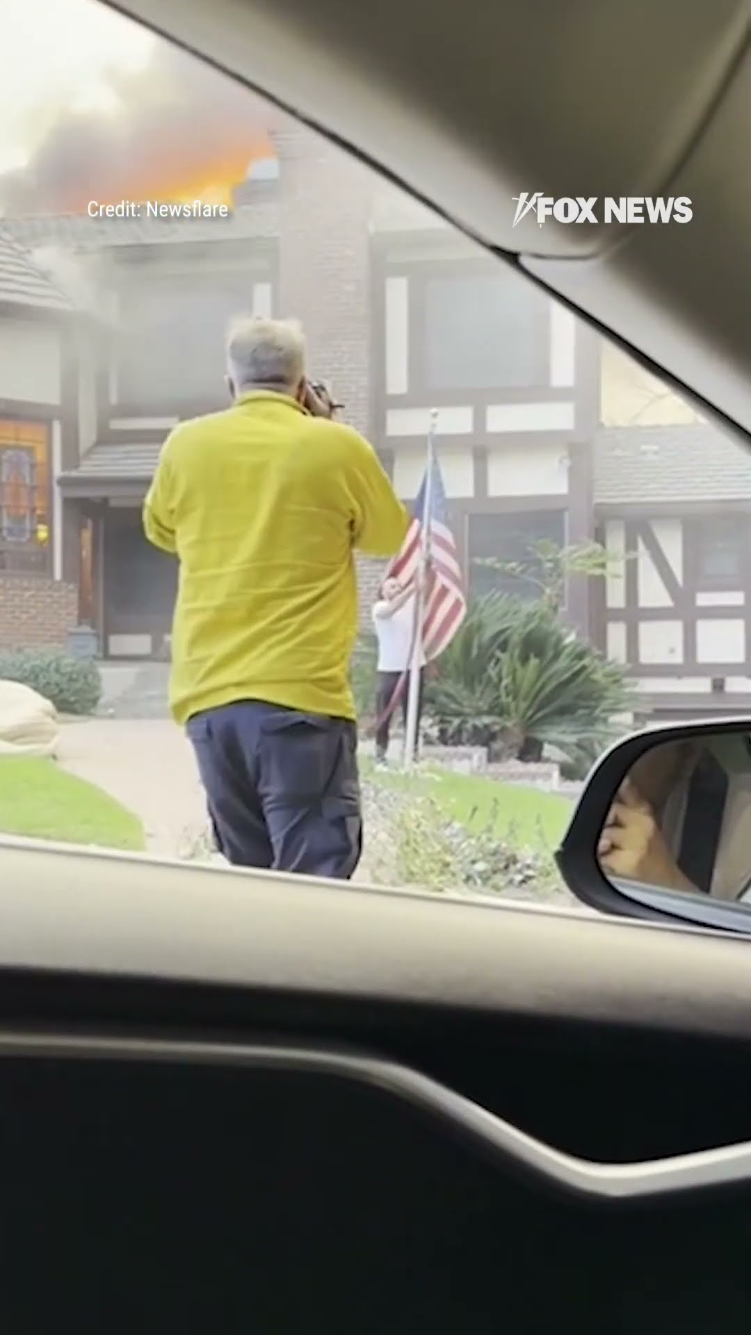 Man rescues American flag from stranger's yard as home burns behind him