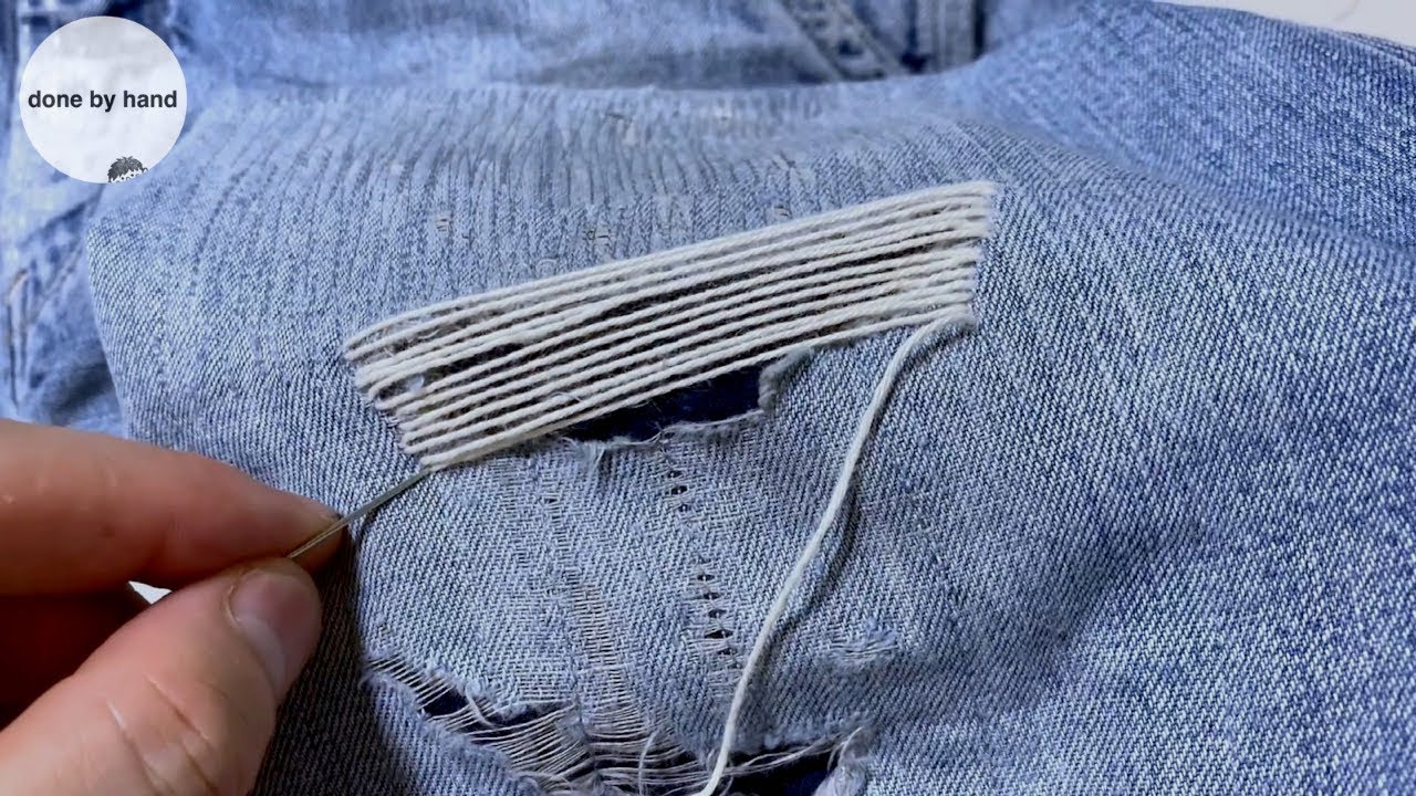 Mending holes in jeans by hand with running stitch