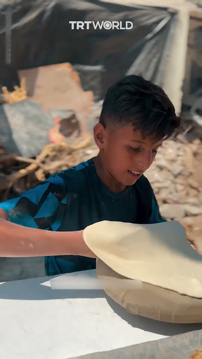 Palestinian child recites Quran while preparing bread
